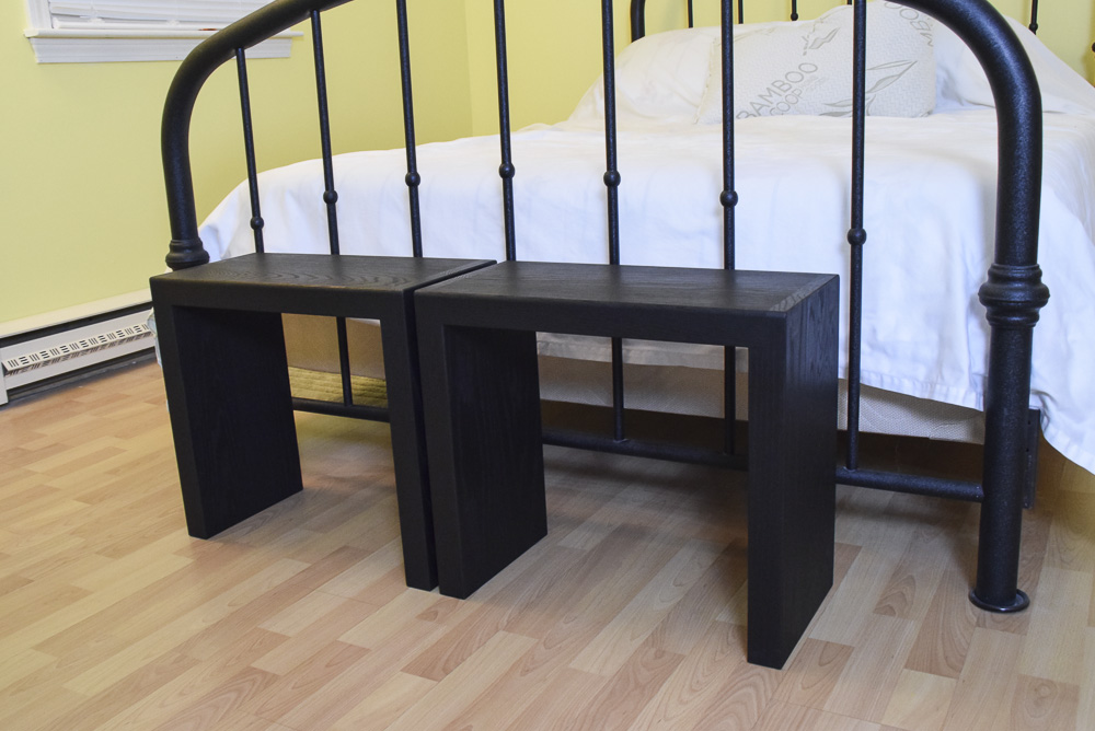 angled view of black oak sitting benches at end of bed