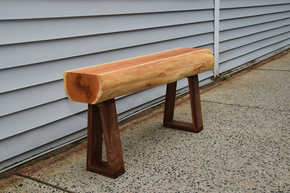 live edge yew bench with walnut legs viewed at an angle